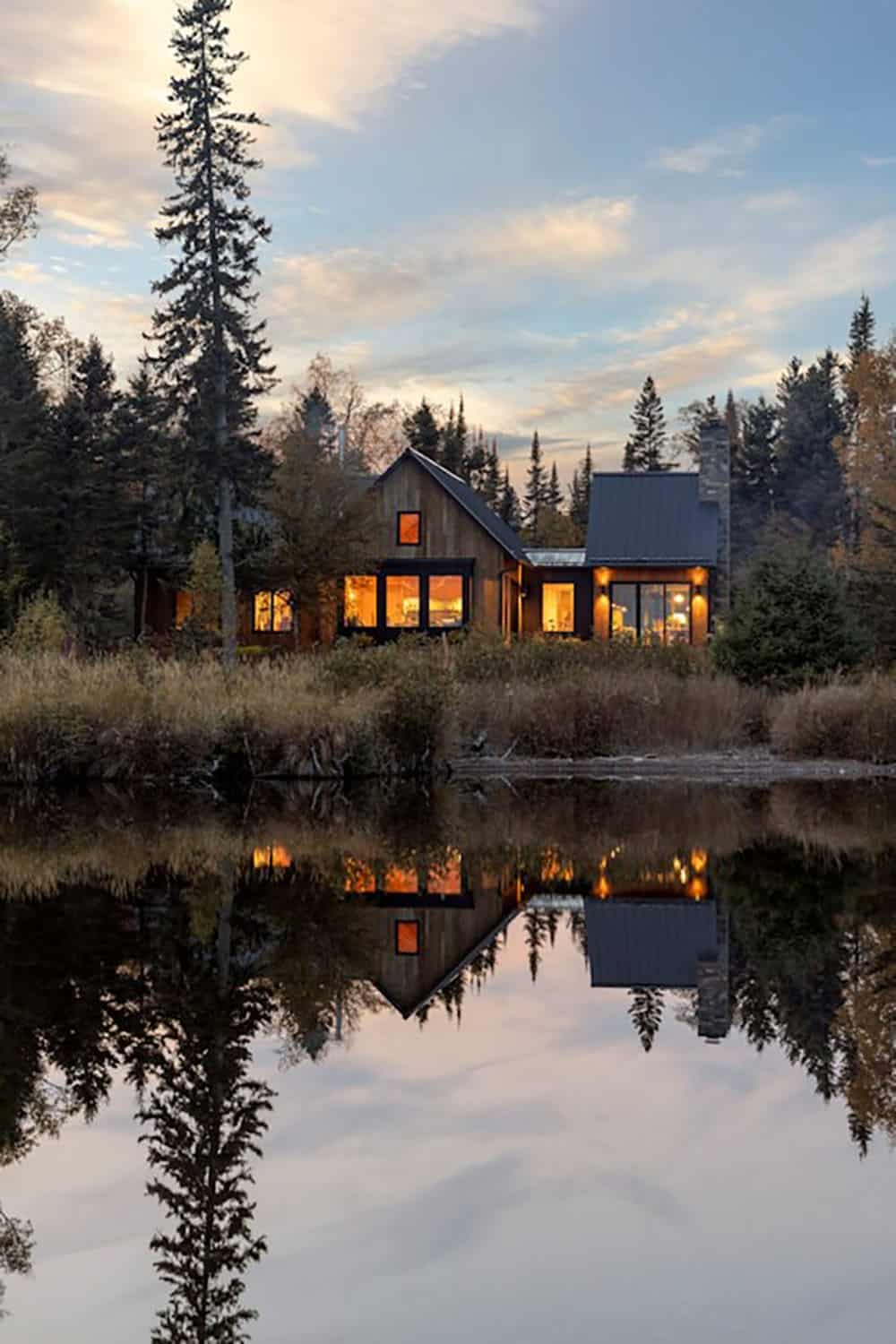 A Minnesota house at dusk, reflected in a lake